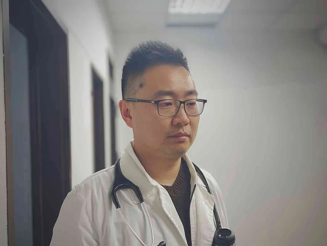 70岁，中国面孔，男，穿着白大褂，手持保温杯，听诊器，戴眼镜，慢慢地走，医院门诊，现代环境，真实，沧桑，疲惫，慈祥，和蔼，温柔 - style4部分