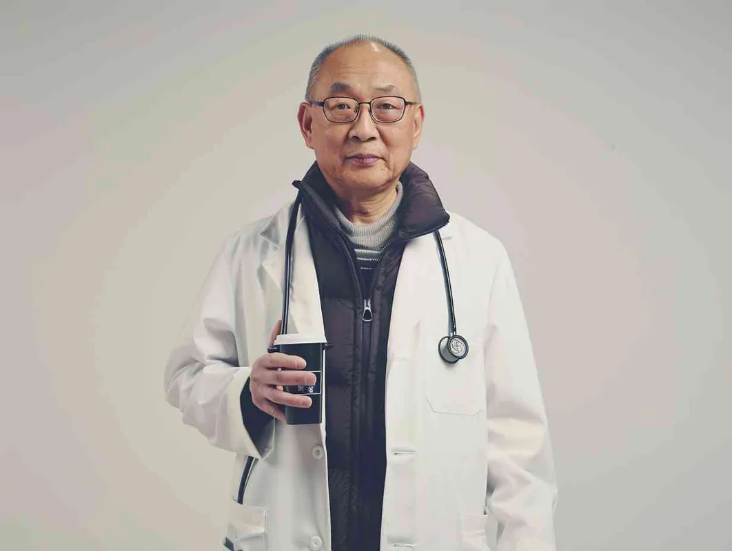 70岁，中国面孔，男，穿着白大褂，手持保温杯，听诊器，戴眼镜，慢慢地走，医院门诊，现代环境，真实，沧桑，疲惫，慈祥，和蔼，温柔 - style4部分