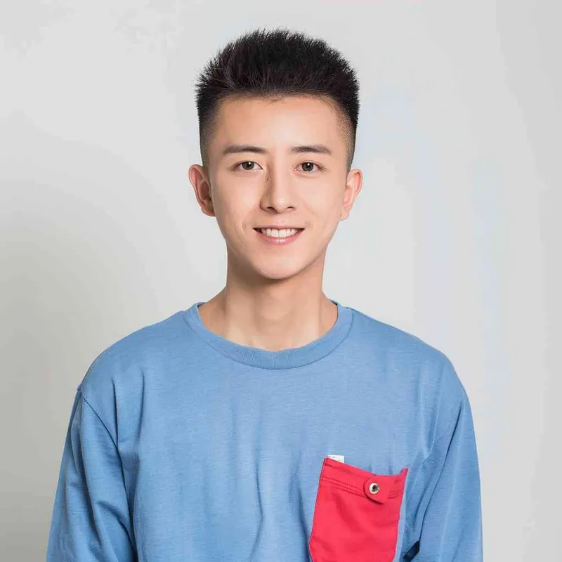 A young Chinese man with short black hair, wearing a blue long-sleeved shirt with a red pocket on the chest area of his right hand is smiling at the camera. The background color should be white to highlight his face. He has an Asian nose shape, medium skin tone, round eyes, and thin eyebrows. His overall appearance conveys friendliness or confidence. in the style of --ar 25:32 - style4部分