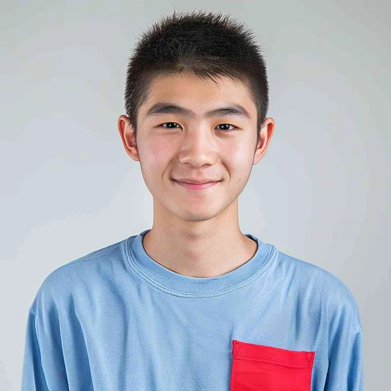 A young Chinese gril with short black hair, wearing a blue long-sleeved shirt with a red pocket on the chest area of his right hand is smiling at the camera. The background color should be white to highlight his face. He has an Asian nose shape, medium skin tone, round eyes, and thin eyebrows. His overall appearance conveys friendliness or confidence. --ar 1:1 --q 1 --v 6.0 - style4部分