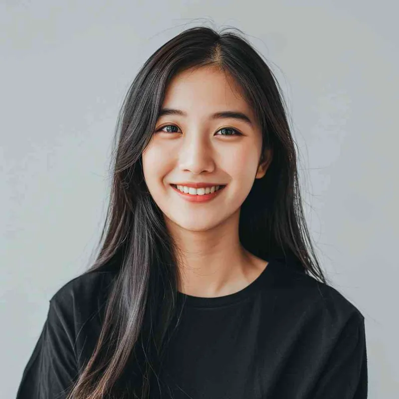 A Chinese girl with long black hair and wearing a dark long-sleeved round-neck T-shirt is smiling at the camera. The background color should be white to highlight his face. She has an Asian nose shape, medium skin tone, round eyes, and thin eyebrows. Her overall appearance conveys friendliness or confidence.--ar 1:1 --q 1 --v 6.0 - style1部分