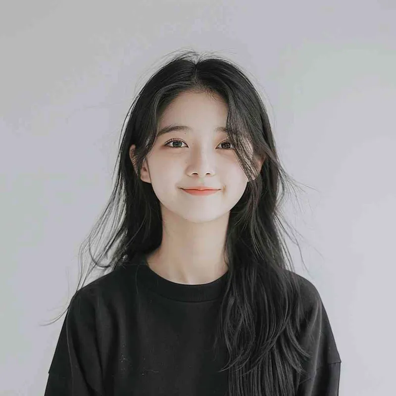 A Chinese girl with long black hair and wearing a dark long-sleeved round-neck T-shirt is smiling at the camera. The background color should be white to highlight his face. She has an Asian nose shape, medium skin tone, round eyes, and thin eyebrows. Her overall appearance conveys friendliness or confidence.--ar 1:1 --q 1 --v 6.0 - style3部分