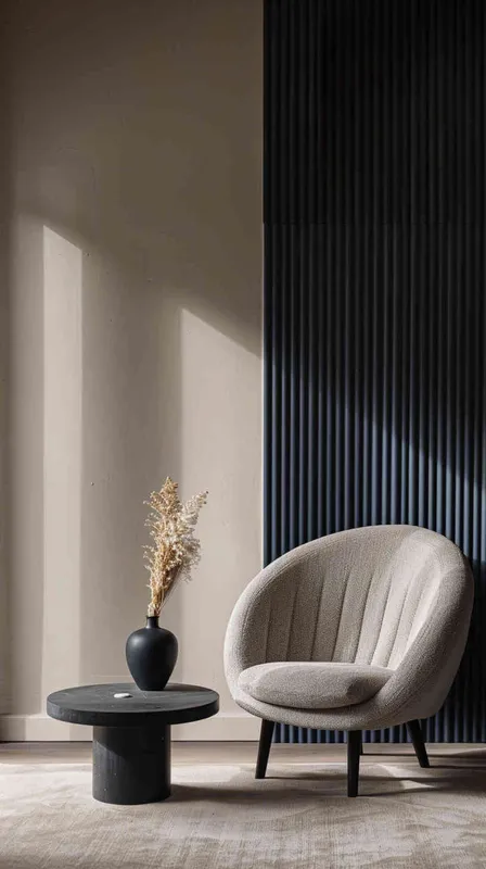 A minimalist living room with a chair andtable, featuring navy blue vertical stripedwall panels on the right side of thepicture. The left side features beige wallscreating an elegant space. A small blackround vase holding dried flowers sitsatop one end. In front stands a simplecoffee table with a single cushion inlight grey color on top of it.--ar 3:4 --s 750 --v 6.0 --style raw - style3部分